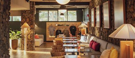 A spacious room with a dining area, a sofa, and a ceiling fan.