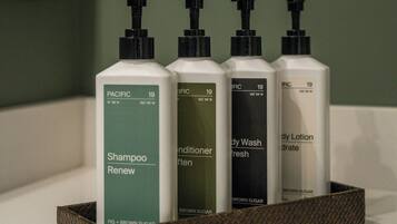 Un estante de baño con cuatro botellas de productos para el cabello.