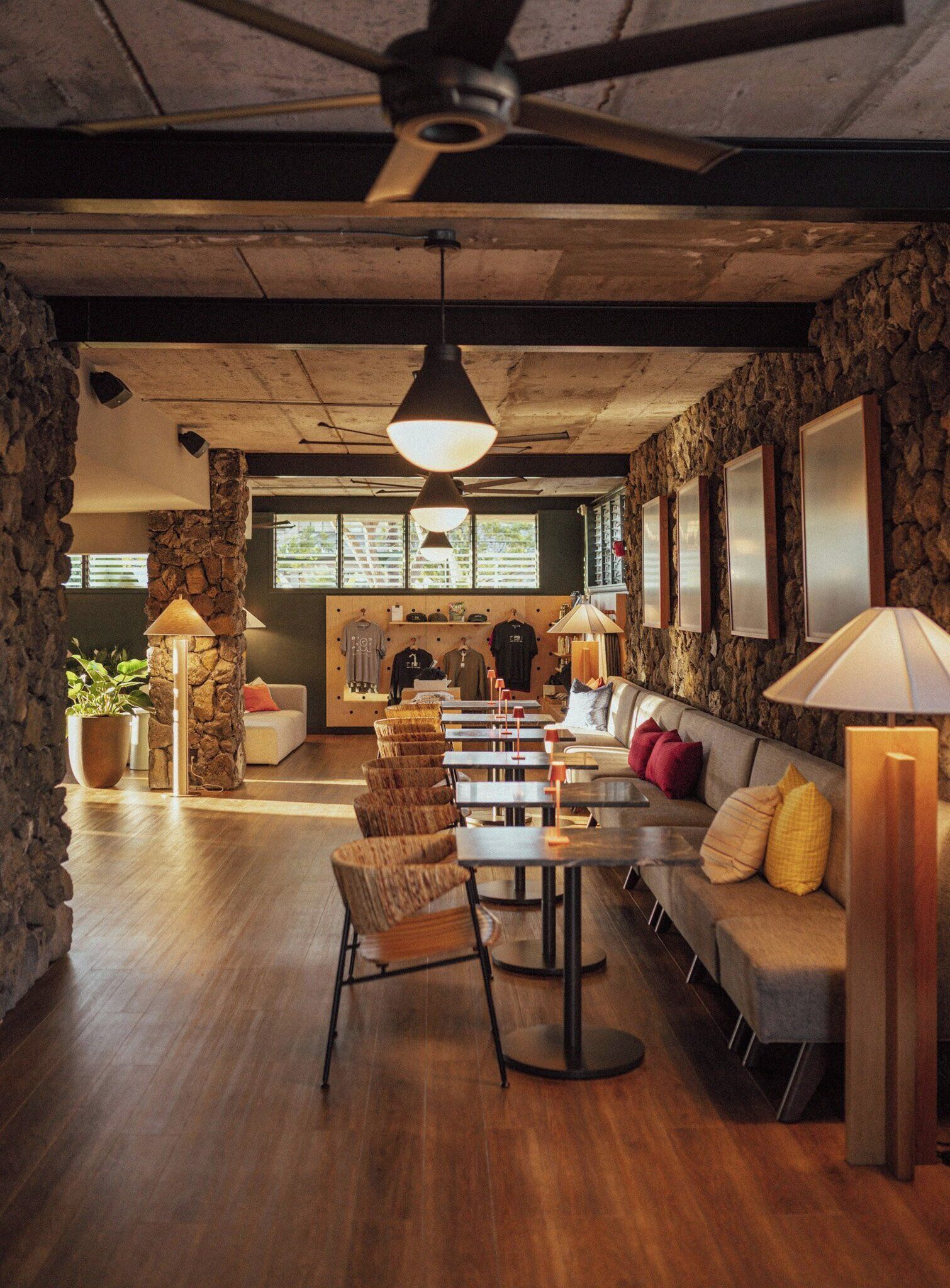 Un interior amplio con comedor, asientos y una cocina al fondo.
