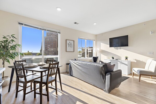 Enjoy a city view from the living area, featuring a sofa, dining table, and flat-screen TV.