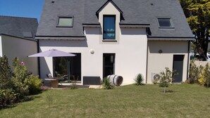 A modern house with a sloped roof, a small front porch, and a large lawn. - Maison 3 Chambres Proche des Plages sur la Presquile de Rhuys (Saint-Gildas-de-Rhuys)