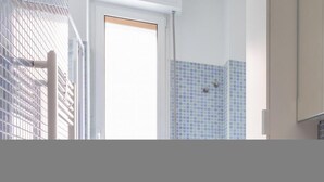 A bathroom with a tiled wall, a shower, and a door. - Italianway Easy - Carlone 5 (Milan)