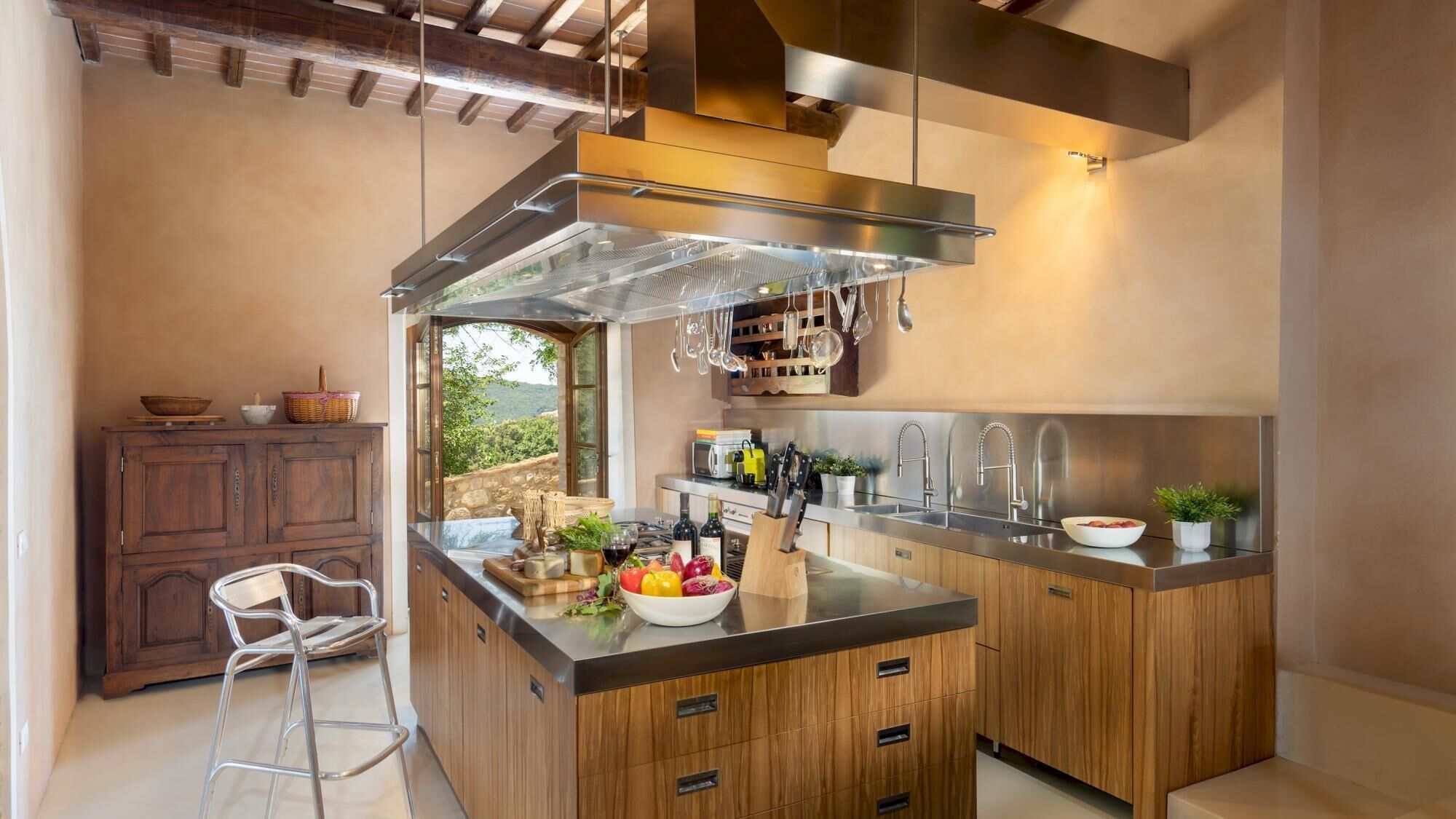Una cocina moderna con una isla central, electrodomésticos de acero inoxidable y armarios de madera.