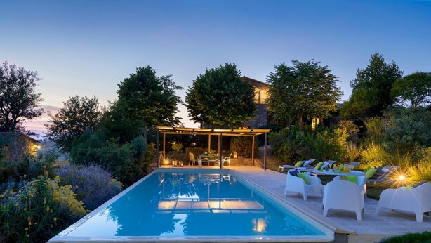 A swimming pool with a covered seating area and lounge chairs. - Pieve di San Giovanni 10 (Pomarance)