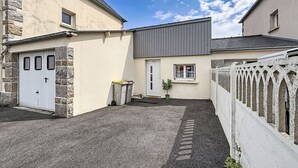 A residential property with a garage, a small front yard, and a white picket fence. - Les Bégonias by Interhome (Saint Malo)