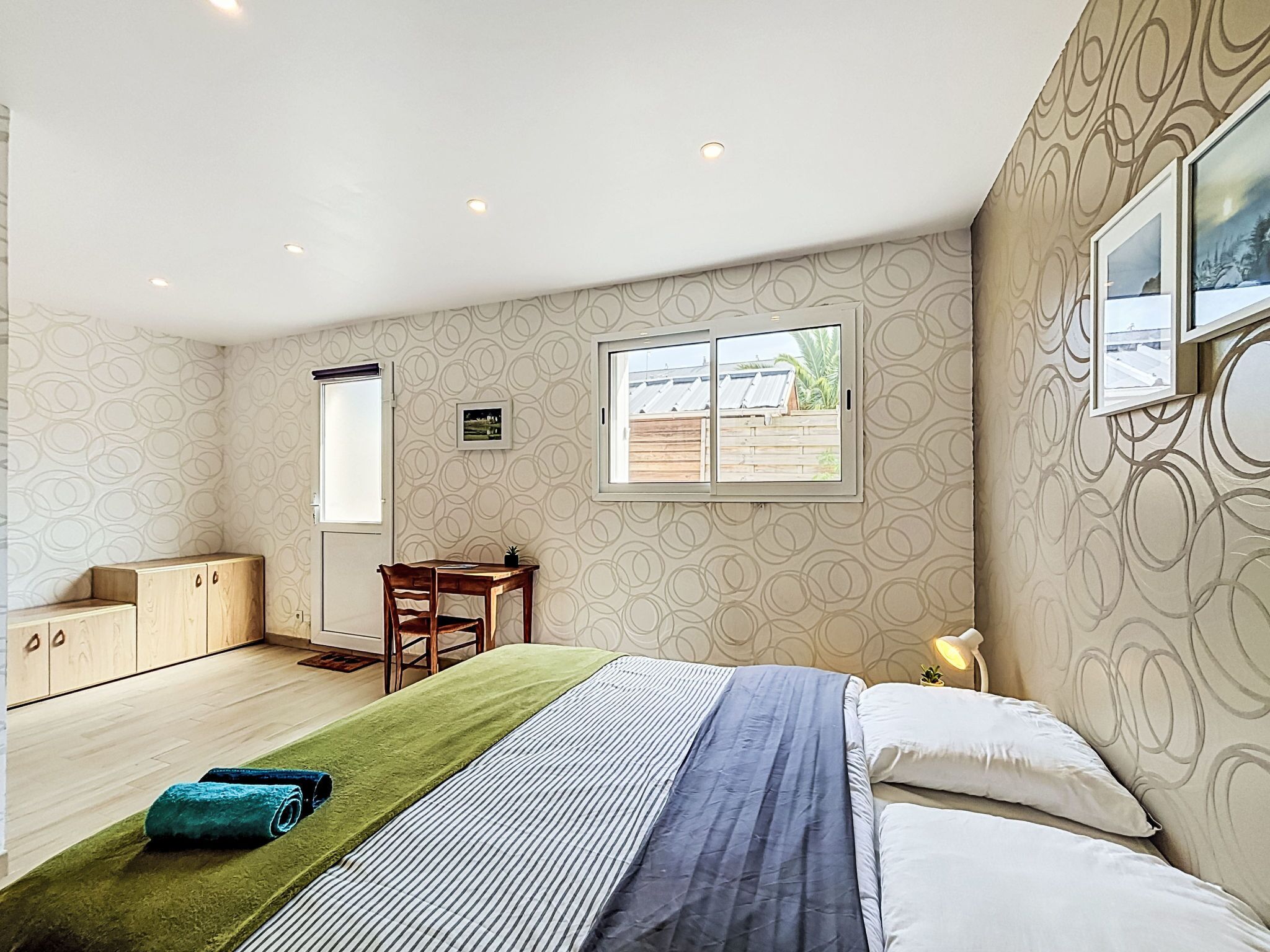 Une chambre à coucher comprenant un lit, un bureau, une chaise, une fenêtre et une armoire.