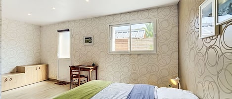 Un dormitorio con cama, escritorio, silla, ventana y armario.