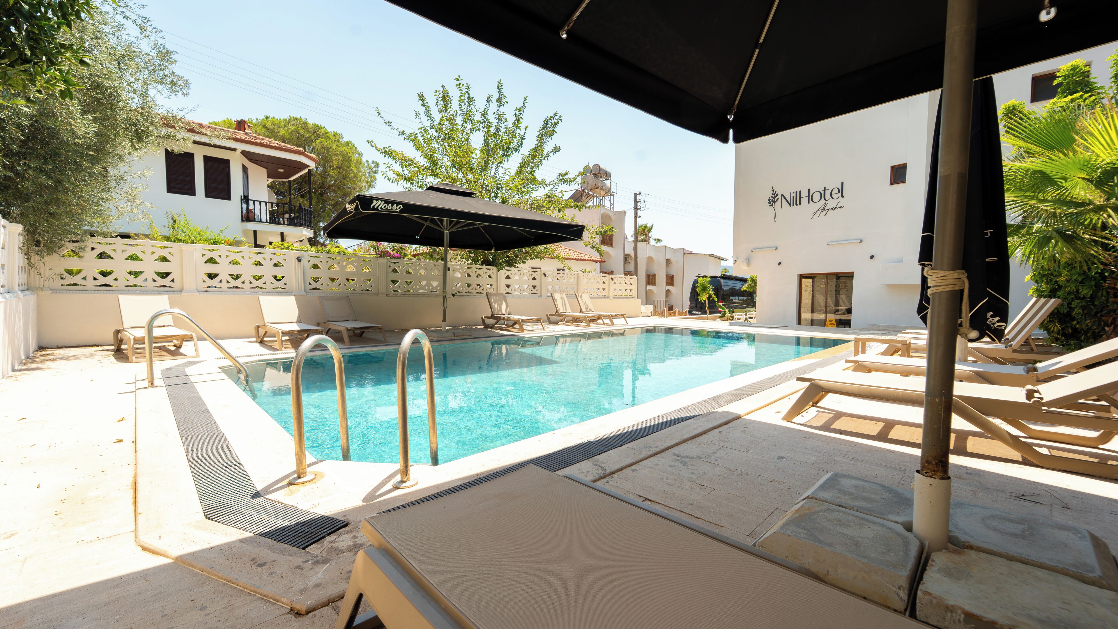 Piscina com espreguiçadeiras e área coberta.