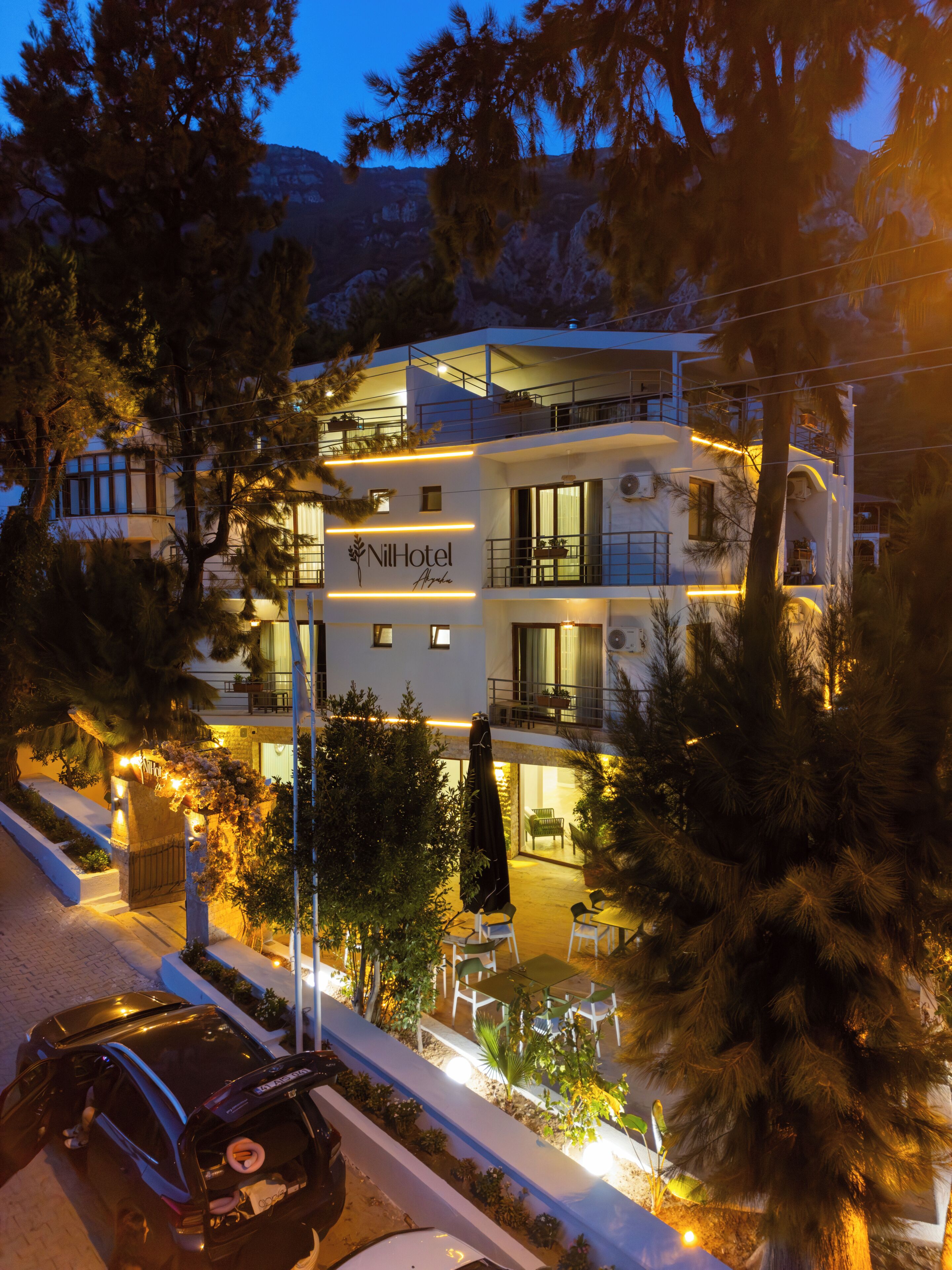 Un hotel de varios pisos con terraza y una entrada visible.