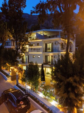 A multi-story hotel with outdoor seating and a visible entrance. - Hotel Nil (Ula)