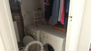 A compact laundry room with a washing machine, dryer, and a small toilet. - Room in shared house in leafy suburban road.  London Zone 4 (Worcester Park)