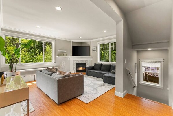 Relax in this stylish living room with a large sectional sofa, flat-screen TV, and cozy fireplace.