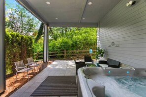 Relax in a serene outdoor oasis with a hot tub and comfortable seating areas.