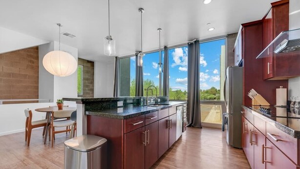 A modern kitchen with a large island, wooden cabinets, and a view of the outdoors. - Exquisite apartment with 2 balconies - Pool!! (Tempe)