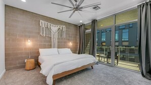 A bedroom with a bed, a ceiling fan, and a large window with curtains. - Exquisite apartment with 2 balconies - Pool!! (Tempe)