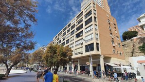 A multi-story building with balconies, a pedestrian area with trees, and outdoor seating. - BENIBEACH (1 BEDROOM) (Benidorm)