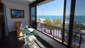 A balcony with a view of the sea, a ceiling fan, and a painting on the wall. - BENIBEACH (1 BEDROOM) (Benidorm)