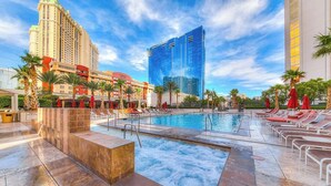 A hotel pool area with a hot tub, lounge chairs, and palm trees. - Strip View MGM Signature  Studio ★ No resort fees (Las Vegas)