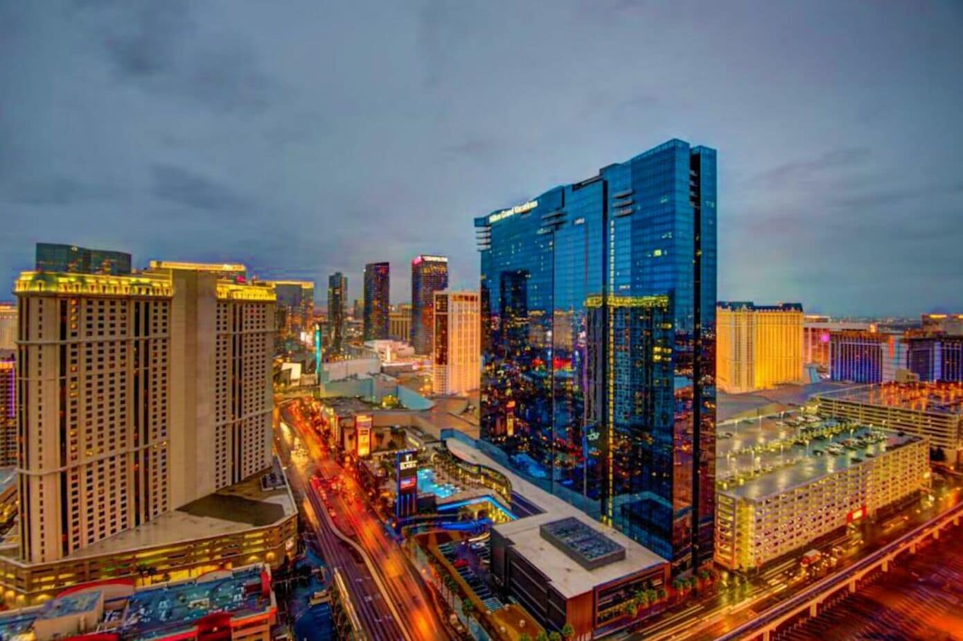 A high-rise hotel with a modern glass facade, located in a busy urban area with surrounding high-rise buildings.