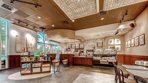 A spacious cafe with a central counter, seating area, and a display of products. - Strip View MGM Signature  Studio ★ No resort fees (Las Vegas)