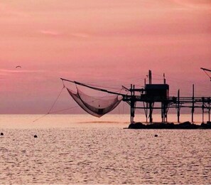 Experience serene coastal fishing at this tranquil pier, where the ocean meets the horizon.