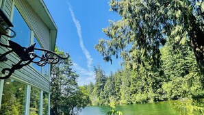 A house with a view of a lake surrounded by trees.