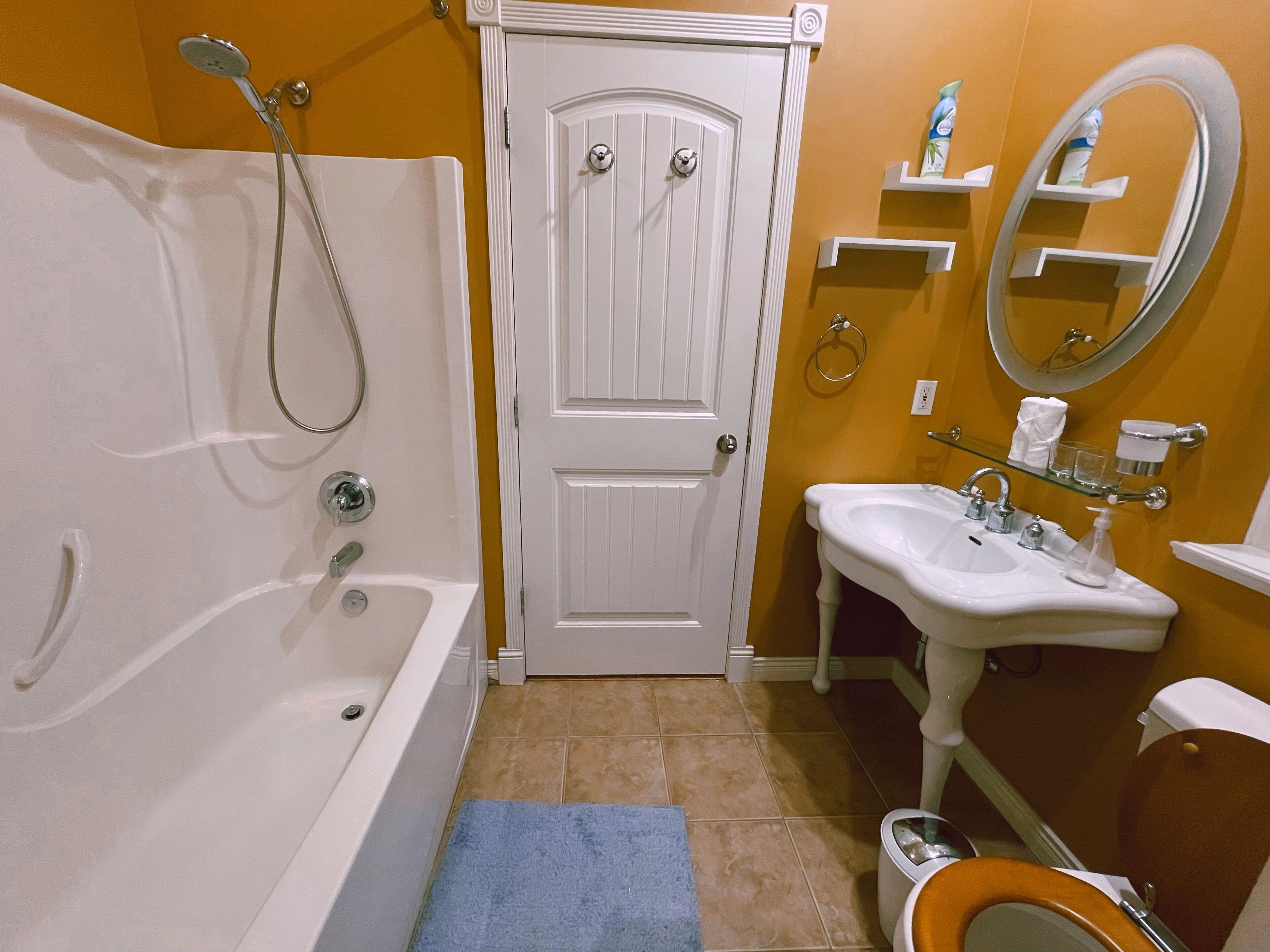Un baño con bañera, lavabo, inodoro y puerta.