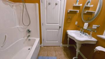Un baño con bañera, lavabo, inodoro y puerta.