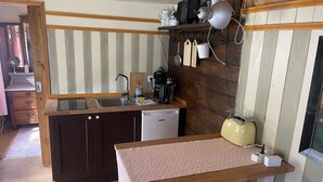 A compact kitchen with a sink, a small refrigerator, and a vintage-style toaster. - Zirkuswagen am Landhaus Labes (Stechlin)