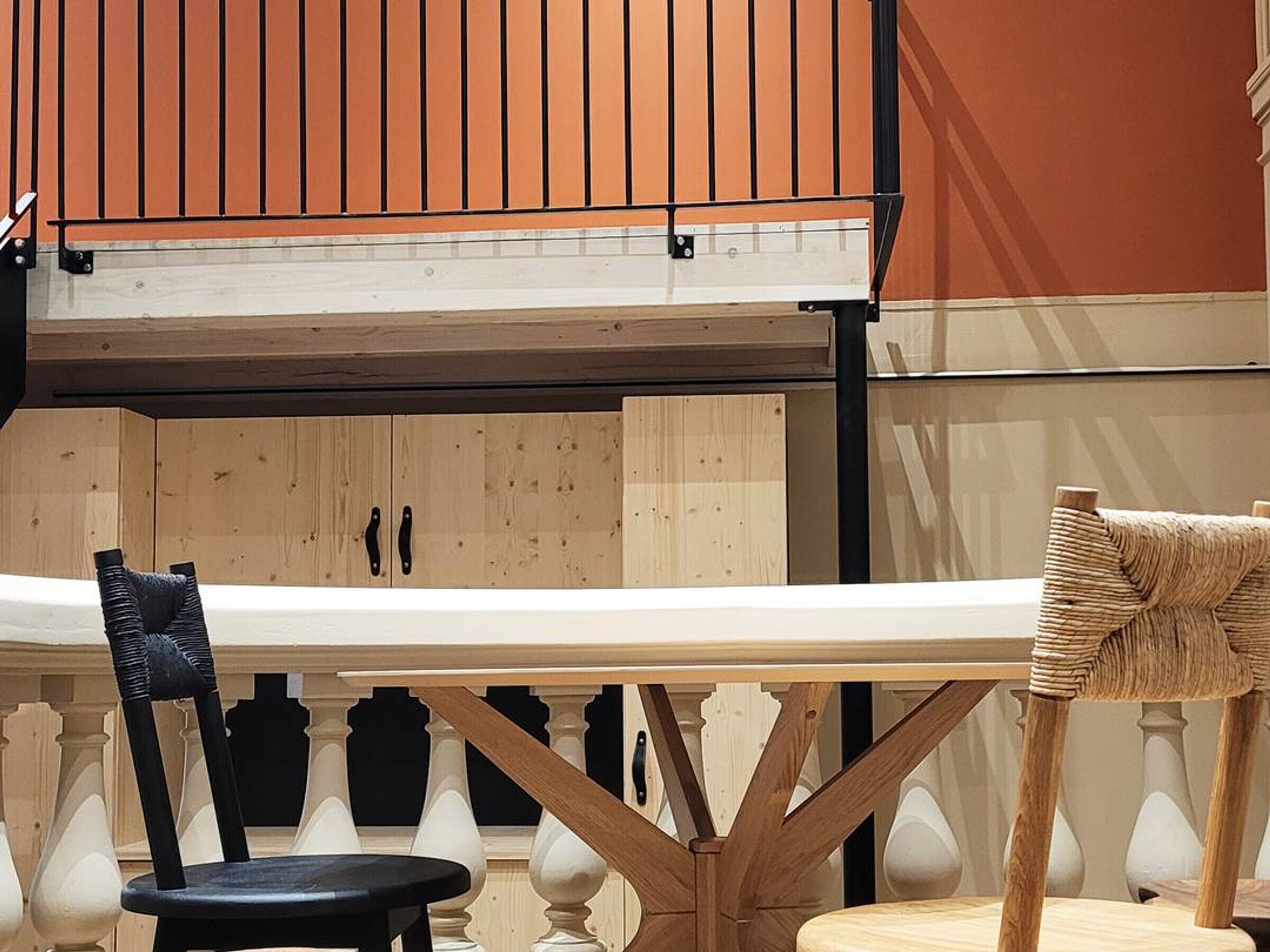 A modern interior with a wooden ceiling, a white table, and two chairs.