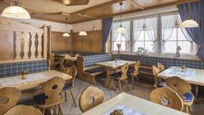 A restaurant with wooden furniture, blue and white checkered booths, and pendant lighting. - Landgasthof Krone (Offingen)