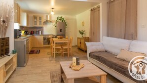A modern apartment with a kitchen, dining area, and living room. - Cozy Gîte with Shared Heated Pool near Angers (Tiercé)