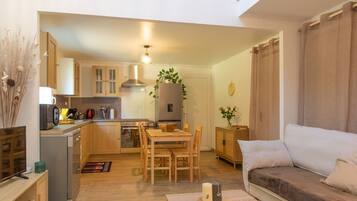 Een modern appartement met keuken, eethoek en woonkamer.