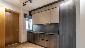A modern kitchen with wooden flooring, a built-in sink, and a large refrigerator. - El Rincón del Baluarte by H - Centro Ayamonte AVHVIIISP (Ayamonte)