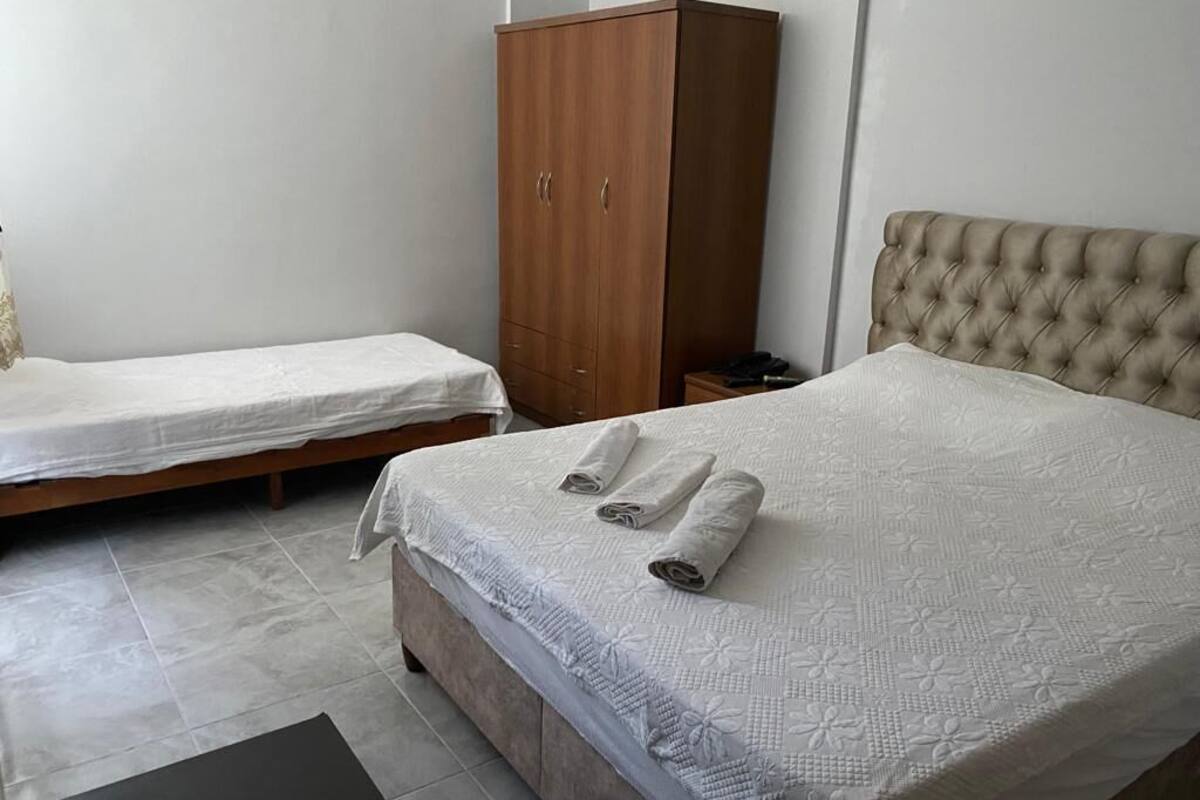 Ein Schlafzimmer mit zwei Betten, einem Kleiderschrank und einem Nachttisch.