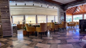 Eine geräumige Lobby mit Schachbrettmuster-Boden, gelben Stühlen und einer großen Holzbalkendecke.