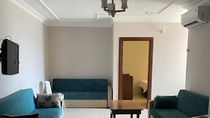 Ein Wohnzimmer mit zwei Sofas, einem Holztisch und einer Deckenleuchte.