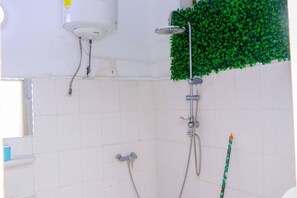 Chuveiro, toalhas de banho, sabonete, papel higiênico