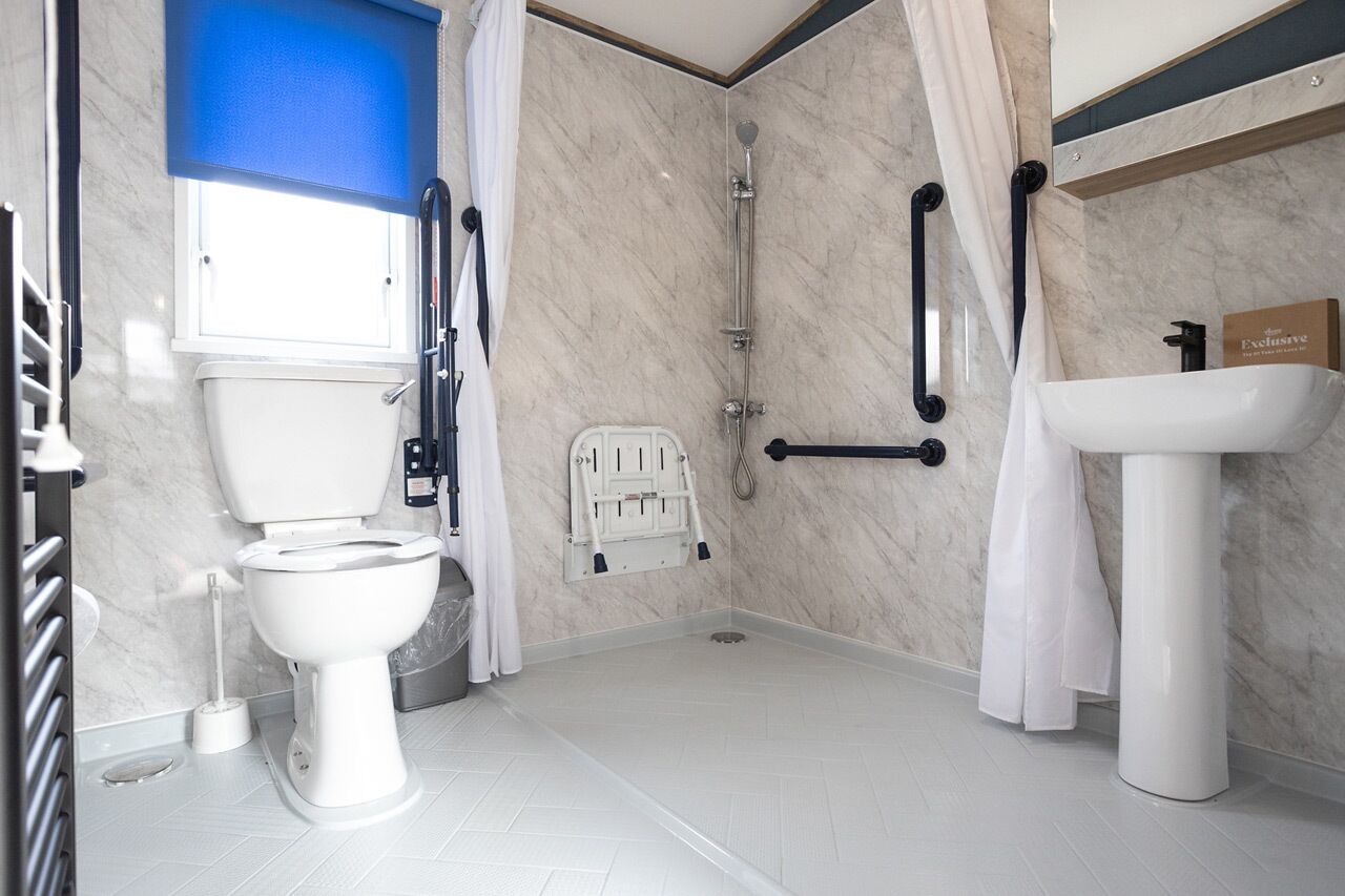 A modern bathroom with a toilet, shower, and sink.
