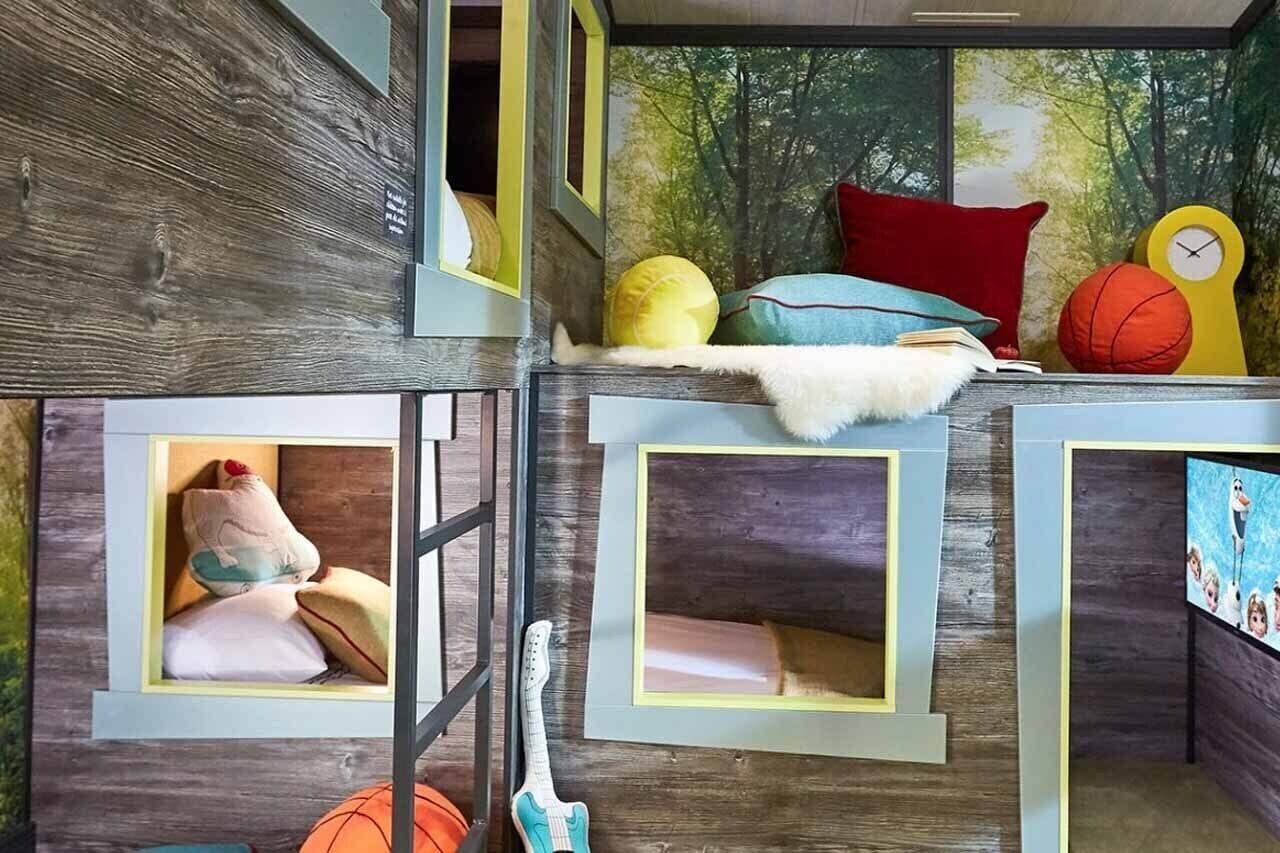 A children's playroom with bunk beds, a guitar, and sports balls.