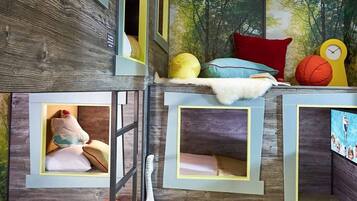 A children's playroom with bunk beds, a guitar, and sports balls.