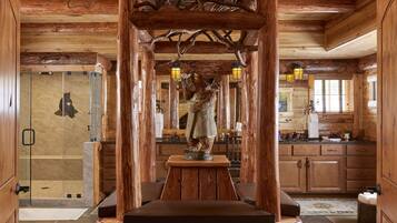 Cozy seating area with a bench and decorative wooden structure, featuring a glass-enclosed shower and functional wooden cabinets.