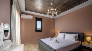 Ein Schlafzimmer mit Bett, Nachttischen, einer Chandelieber, einer Klimaanlage und einem Fenster.