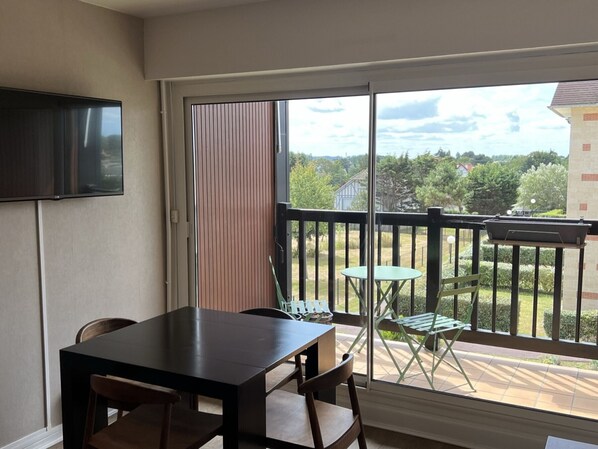 Enjoy a room with a balcony offering a view of the outdoors, featuring a table and chair.