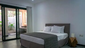 Un dormitorio moderno con una cama grande, un ventanal corredero que da a un balcón y una mesita de noche pequeña.