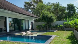 Una casa moderna con piscina, amplias ventanas y un jardín bien cuidado.