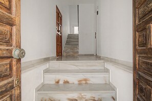 A staircase with marble steps leading to a door at the top.