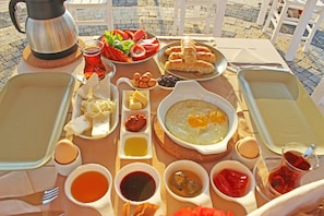 A table set with a variety of breakfast items including eggs, bread, and sauces.