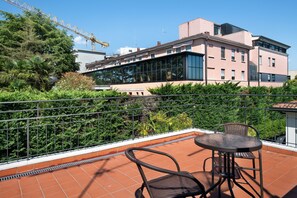 A terrace with a metal railing, a table, and two chairs. - Studio Apartment 'Civico22 - Mans 1' with Terrace, Air Conditioning and Wi-Fi (Peschiera del Garda)