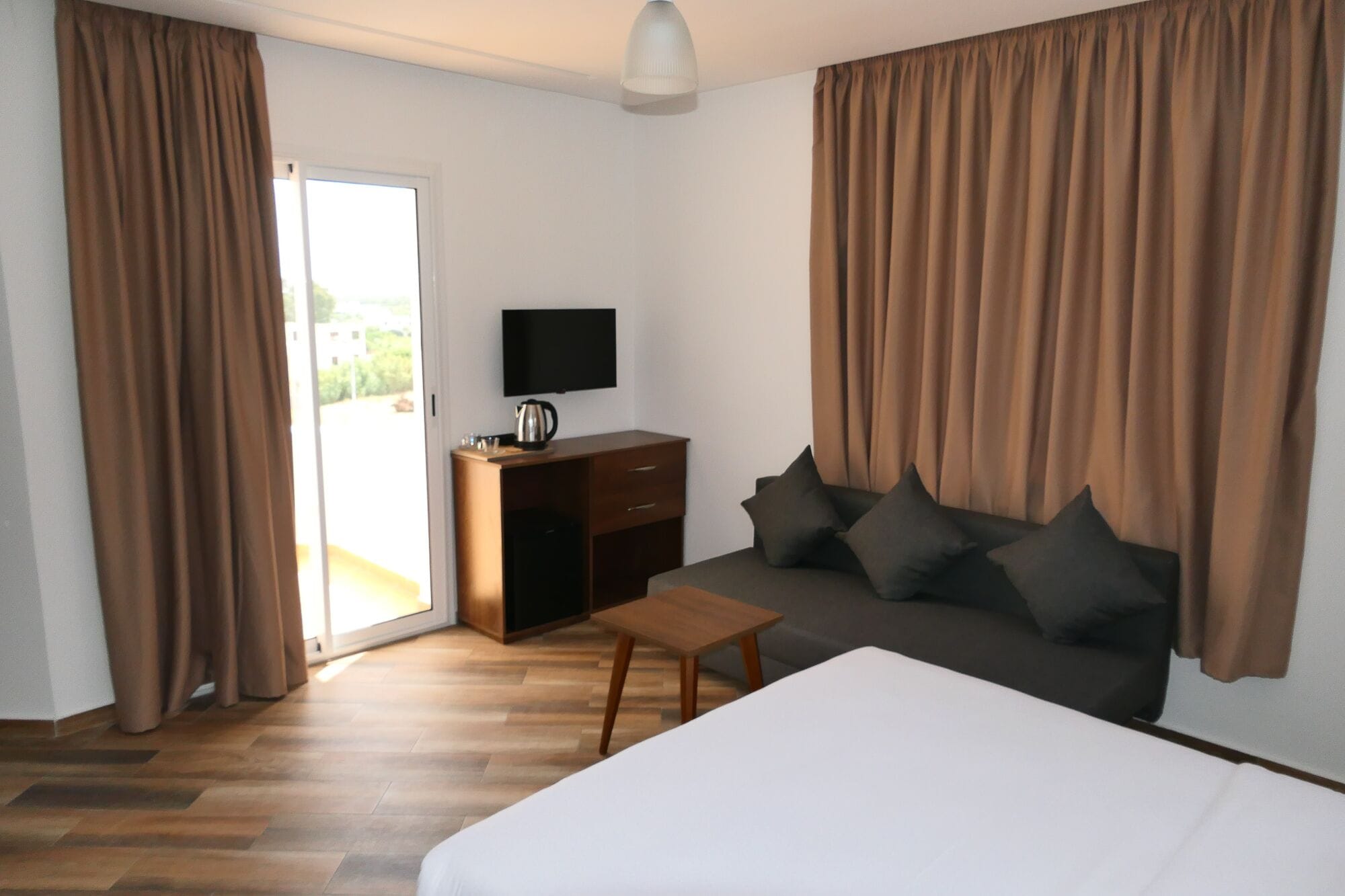 Une chambre d’hôtel équipée d’un lit, d’un canapé, d’une télévision, d’un bureau et d’une machine à café.